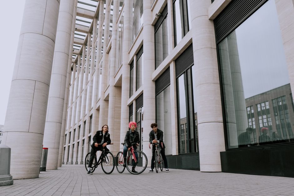 Trois cyclistes réunis avec leurs vélos dans l'espace public