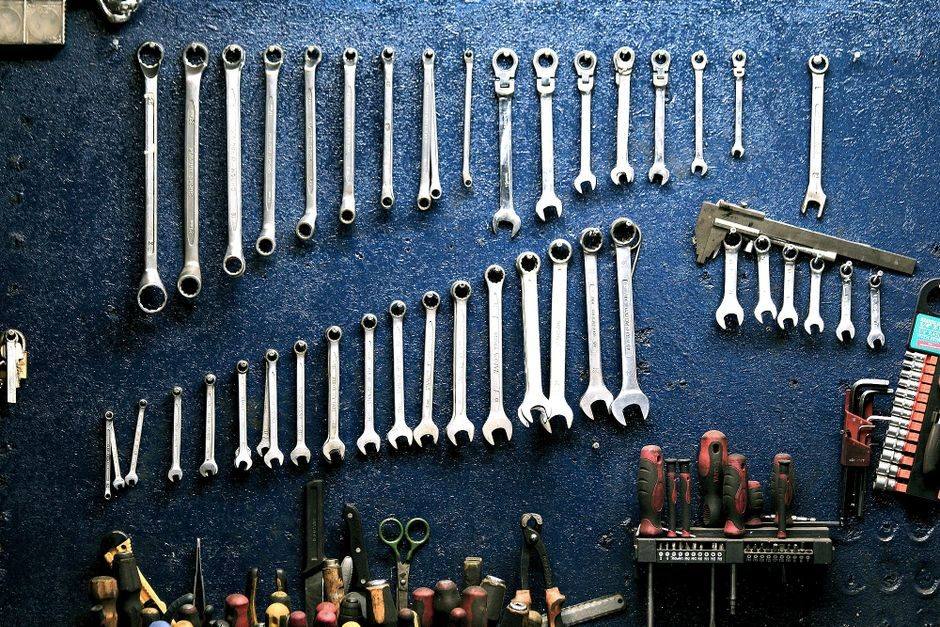 Clés et outils de mécanique cycle rangés sur le panneau de l'établi