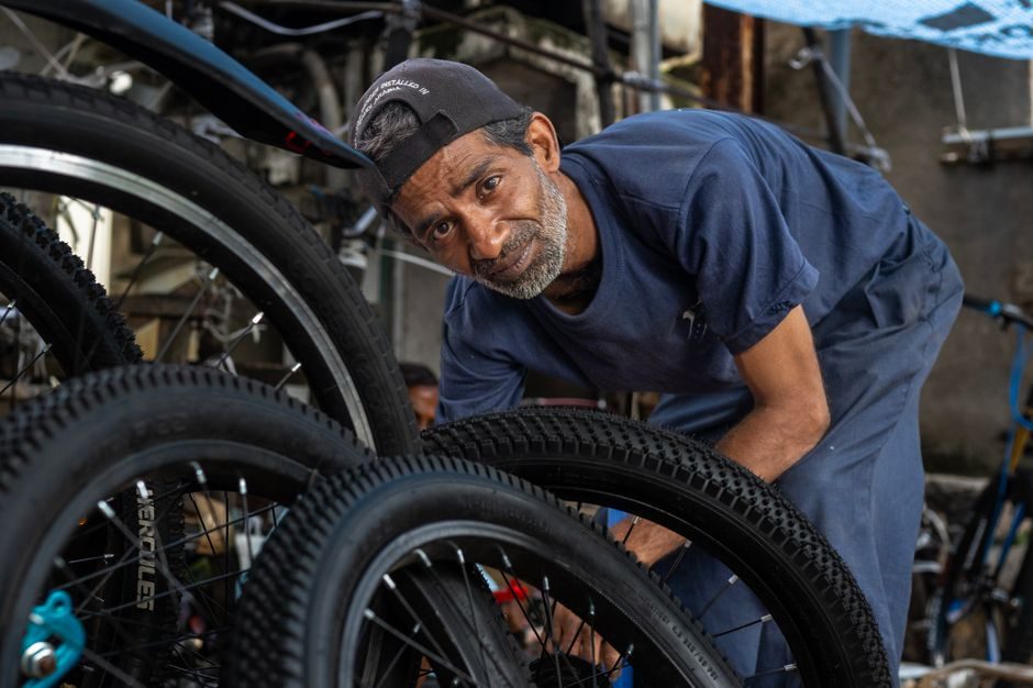Mécanicien cycle inspectant un pneu de vélo dans l'atelier